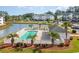 Scenic view of community pool, clubhouse, and meticulously maintained landscaping with mature palm trees at 750 Charter Dr. # E-2, Longs, SC 29568