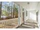 View of screened-in back porch overlooking trees, with white railings and trim at 750 Charter Dr. # E-2, Longs, SC 29568