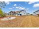 Spacious backyard featuring a covered patio, fire pit, and well-maintained lawn under a bright, cloudy sky at 820 Wild Leaf Loop, Conway, SC 29526