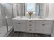 Bright bathroom featuring double vanity, quartz countertops, and a glass-enclosed shower with marble tiling at 860 Saluda River Rd., Myrtle Beach, SC 29588