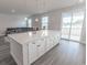 Large kitchen island with quartz countertop, storage, and seating, leading to the living room at 860 Saluda River Rd., Myrtle Beach, SC 29588