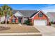 Charming brick home featuring a two-car garage, manicured lawn, and a welcoming entryway at 862 Edgewater Dr., Murrells Inlet, SC 29576