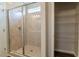 Bathroom showcasing a glass-enclosed shower with tiled walls and a built-in storage shelf at 92 Costa Ct., Pawleys Island, SC 29585