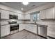 Bright kitchen with white cabinets, stainless steel appliances, and hardwood-style flooring at 935 Little Creek Rd., Myrtle Beach, SC 29572