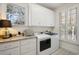 Well-organized laundry room offers a granite countertop, white cabinetry and large window at 938 Wallace Pate Dr., Georgetown, SC 29440