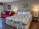 Cozy bedroom with a red sofa, tropical-themed decor and wood-style laminate flooring at 9820 Queensway Blvd. # 706, Myrtle Beach, SC 29572