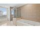 Bright bathroom features a large window, glass shower, and soaking tub at 9994 Beach Club Dr. # 2408, Myrtle Beach, SC 29572