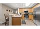 Well-lit kitchen with stainless steel appliances, granite countertops, and a breakfast bar at 9994 Beach Club Dr. # 2408, Myrtle Beach, SC 29572