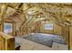 Unfinished attic space with exposed wood beams, insulation, and natural light from windows at 1 Sun Ct., Carolina Shores, NC 28467