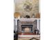 Close-up of a stone fireplace with a mantel decorated with candles, baskets, and an elephant sculpture at 1 Sun Ct., Carolina Shores, NC 28467