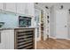 Stylish kitchen with stainless steel wine cooler, custom cabinetry, and a view into sunroom at 1 Sun Ct., Carolina Shores, NC 28467