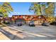 Brick townhome featuring a multi-car parking area, wood-shingled roofing, and mature landscaping at 1025 Carolina Rd. # Ee-1, Conway, SC 29526