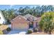 Charming brick home featuring an attached two-car garage and mature landscaping, including a palm tree at 110 Summerlight Dr., Murrells Inlet, SC 29576