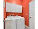 Clean laundry room with bright red walls, cabinets and front-loading washer and dryer units at 110 Summerlight Dr., Murrells Inlet, SC 29576