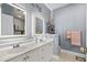 Bathroom featuring double sink vanity with framed mirrors, tiled floors, and modern lighting at 118 Gully Branch Ln. # 3, Myrtle Beach, SC 29572