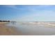 Expansive beach scene featuring gentle waves and distant figures under a clear sky at 126 Bayou Loop # Lot 11, Surfside Beach, SC 29575