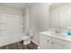 Bright bathroom featuring a shower-tub combo, gray wood-look floors, toilet and white vanity with sink at 1434 Porchfield Dr., Conway, SC 29526