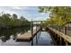 Wooden dock with weathered wood, green railing, and bridge in the distance on a tranquil river at 1434 Porchfield Dr., Conway, SC 29526