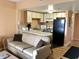 Inviting living area with a comfortable sofa, adjacent to a kitchen with black appliances and a breakfast bar at 1605 S Ocean Blvd. # 106, Myrtle Beach, SC 29577