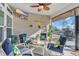 Relaxing screened-in porch featuring comfortable seating, ceiling fan, TV, and view of the backyard at 166 New Paradise Way, Myrtle Beach, SC 29588
