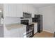 Corner view of the kitchen with stainless microwave and a black refrigerator and range at 2005 Havens Dr., North Myrtle Beach, SC 29582