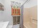 This bathroom has a window with wooden shutters and a cream colored bathtub and shower with a gray shower curtain at 2166 Marion Circle, Little River, SC 29566