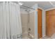 This is a tub and shower combination with a white shower curtain rod and a white shower curtain with a blue floral print at 2166 Marion Circle, Little River, SC 29566