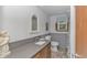 This bathroom has wainscoting, a modern vanity with gray countertop, and a woven-look mirror over the sink at 2166 Marion Circle, Little River, SC 29566