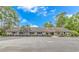 The building exterior is light gray with a black entryway, manicured landscaping, and plentiful parking at 2166 Marion Circle, Little River, SC 29566
