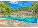 Large community pool with ample seating and beautiful landscaping surrounded by lush greenery and bright blue sky at 2166 Marion Circle, Little River, SC 29566