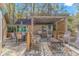 This covered patio has a grill, outdoor seating, overhead lighting, and landscaping providing shade and privacy at 2166 Marion Circle, Little River, SC 29566