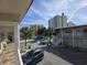 Property exterior with a parking area, palm trees, and a glimpse of the beach skyline in the distance at 2204 S Perrin Dr. # 3, North Myrtle Beach, SC 29582