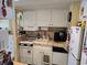 Functional kitchen with white cabinetry, compact appliances, and tile backsplash at 2204 S Perrin Dr. # 3, North Myrtle Beach, SC 29582