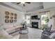 Bright living room with fireplace, ceiling fan, and large windows at 327 Dunlin Pl, Conway, SC 29526