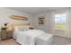 A neutral and nautical bedroom with a surfboard, wall decor, and window views at 335 Glade Ct., Loris, SC 29569