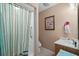Bathroom featuring a shower with striped curtain, wood cabinet, and shell-themed artwork at 6001- 5411 S Kings Highway, Myrtle Beach, SC 29575