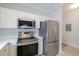 Modern kitchen with stainless steel refrigerator, microwave, and white cabinets for ample storage at 6015 Catalina Dr. # 734, North Myrtle Beach, SC 29582