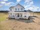 A charming two-story home featuring a covered front porch with rocking chairs and a carport at 11455 W Highway 19, Loris, SC 29569