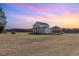 Exterior view of a charming two-story farmhouse with a spacious front yard and a covered carport at 11455 W Highway 19, Loris, SC 29569