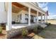 Inviting front porch with rocking chairs, wooden ceiling, and an American flag at 11455 W Highway 19, Loris, SC 29569