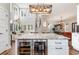 A modern kitchen island featuring a wine cooler, marble countertop, and a custom light fixture at 11455 W Highway 19, Loris, SC 29569