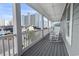 Spacious balcony featuring white rocking chairs and railings, offering a view of nearby buildings and palm trees at 119 Sunset Dr., Murrells Inlet, SC 29576