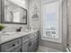 A bathroom with a granite countertop, gray cabinets, and beach themed decorations at 119 Sunset Dr., Murrells Inlet, SC 29576