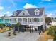 Charming raised beach house with a porch, columns, and well-maintained landscaping in a coastal setting at 119 Sunset Dr., Murrells Inlet, SC 29576