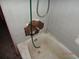 View of a damaged bathroom with peeling tiles and a stained tub at 12 E Sassafras St., Andrews, SC 29510