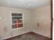 An interior view of a bedroom with damaged walls, peeling paint, and a boarded window at 12 E Sassafras St., Andrews, SC 29510