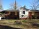 A single-story brick home with boarded windows under a clear blue sky at 12 E Sassafras St., Andrews, SC 29510