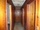 Long hallway with paneled wood walls and outdated ceiling at 12 E Sassafras St., Andrews, SC 29510