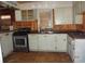 Outdated kitchen featuring white cabinets, stainless steel appliances, and a sink at 12 E Sassafras St., Andrews, SC 29510