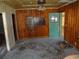 Interior shot of damaged floors with a bare ceiling fan and a door at 12 E Sassafras St., Andrews, SC 29510